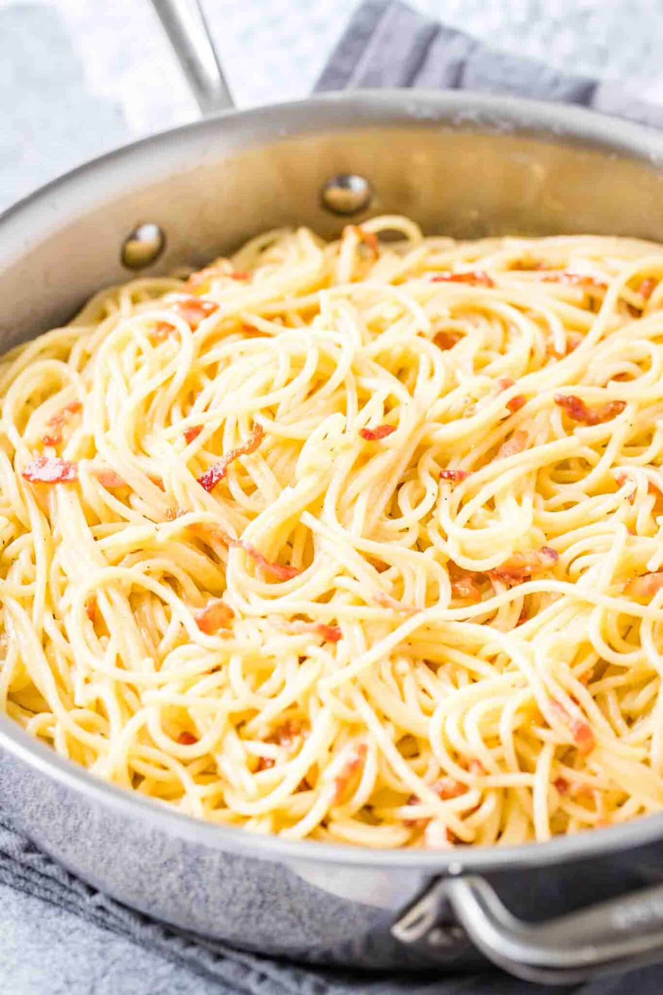 Une poêle en acier inoxydable avec des spaghetti carbonara