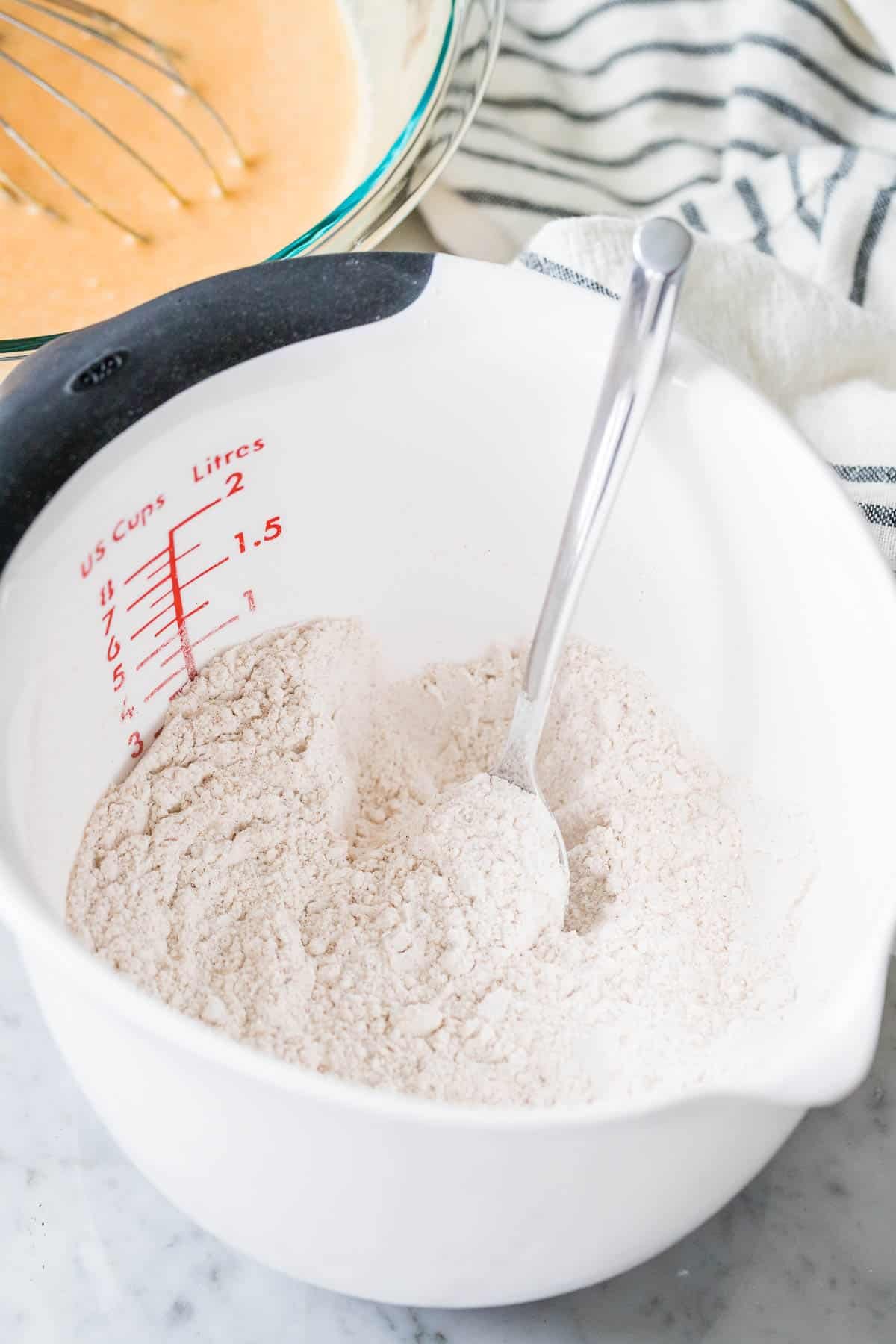 Ingrédients secs dans un bol de mesure avec une cuillère.