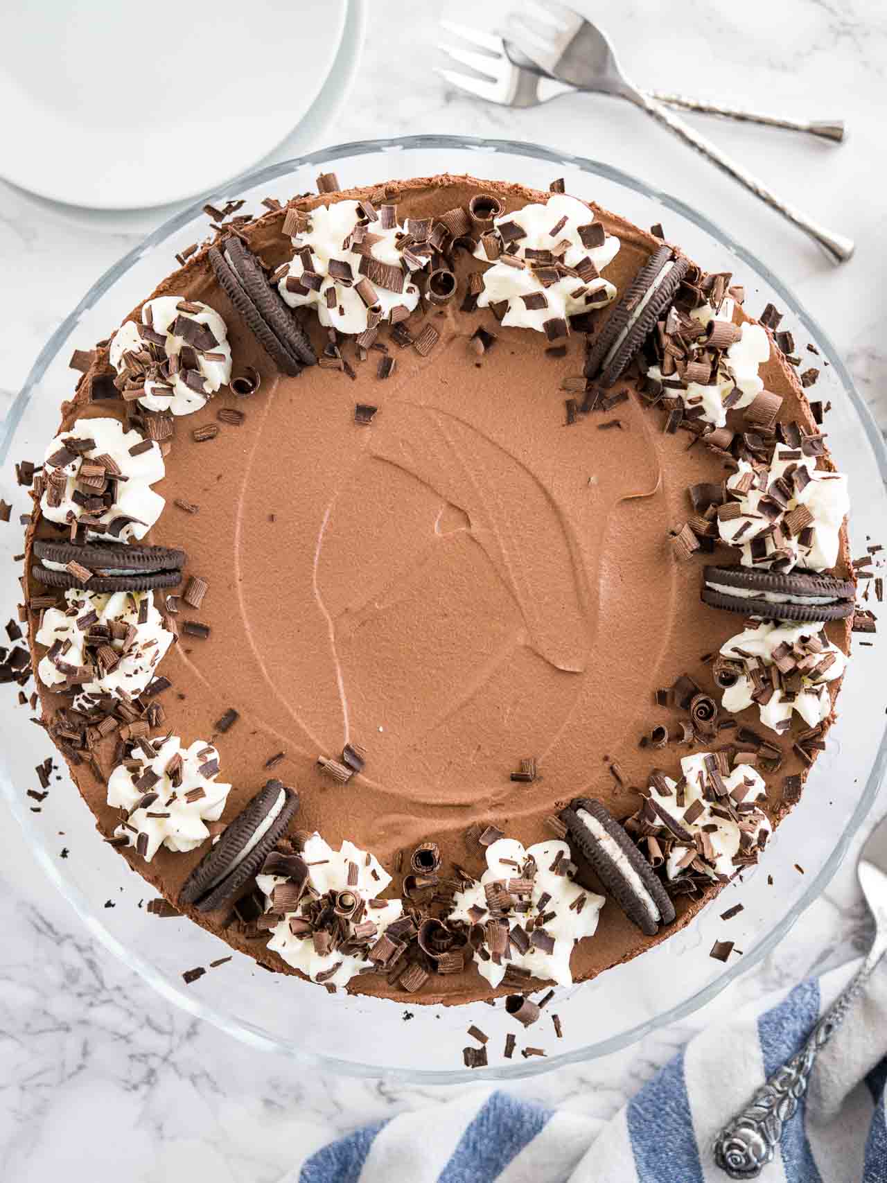 Un gâteau mousse sans cuisson garni de biscuits Oreo, de crème fouettée et de copeaux de chocolat.