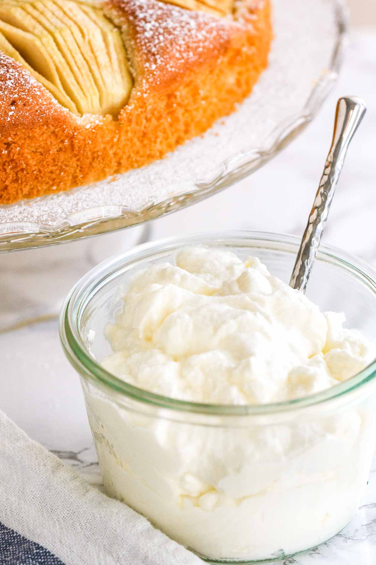 Crème chantilly dans un pot en verre avec une cuillère.