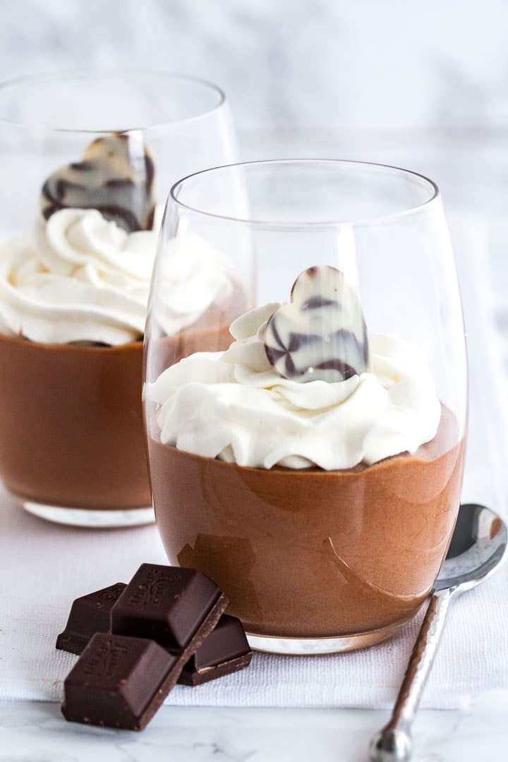 Mousse au chocolat dans un verre, surmontée de crème chantilly.