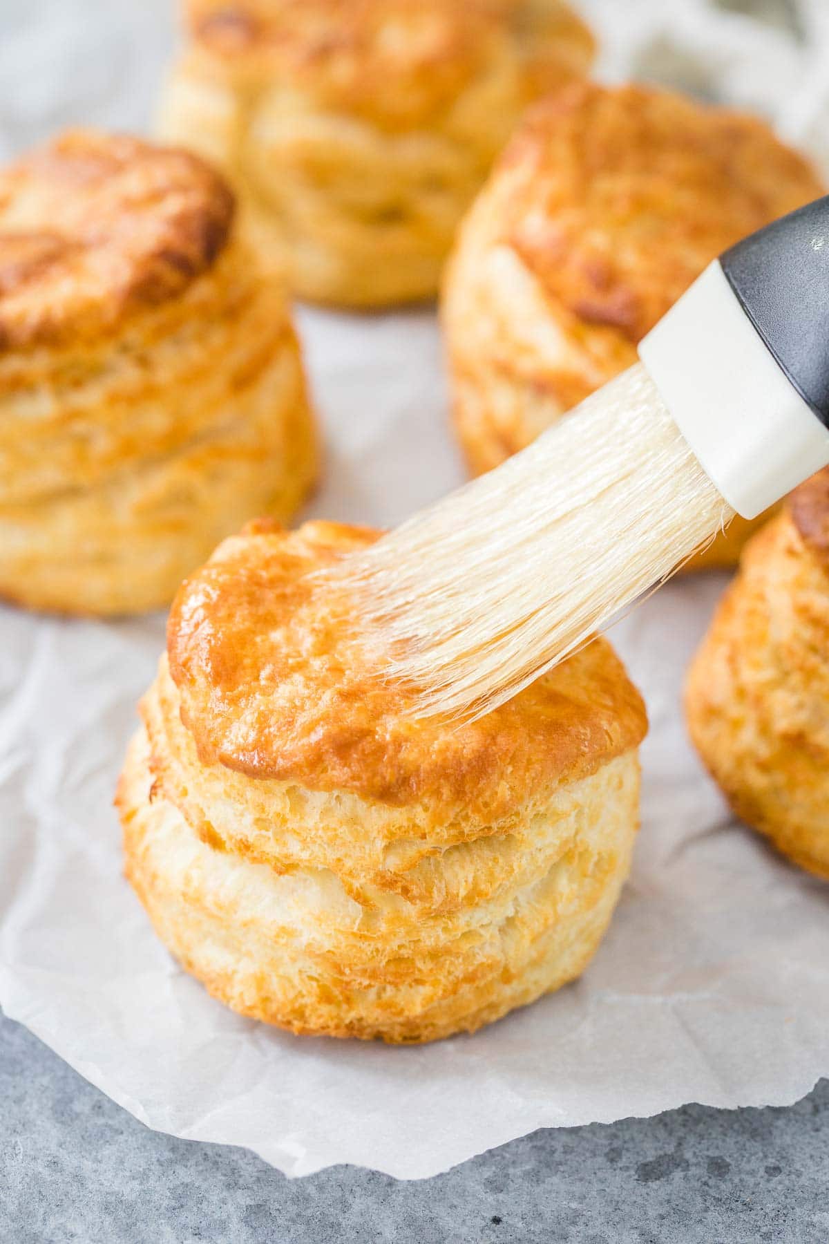 Du beurre étant badigeonné sur un biscuit.