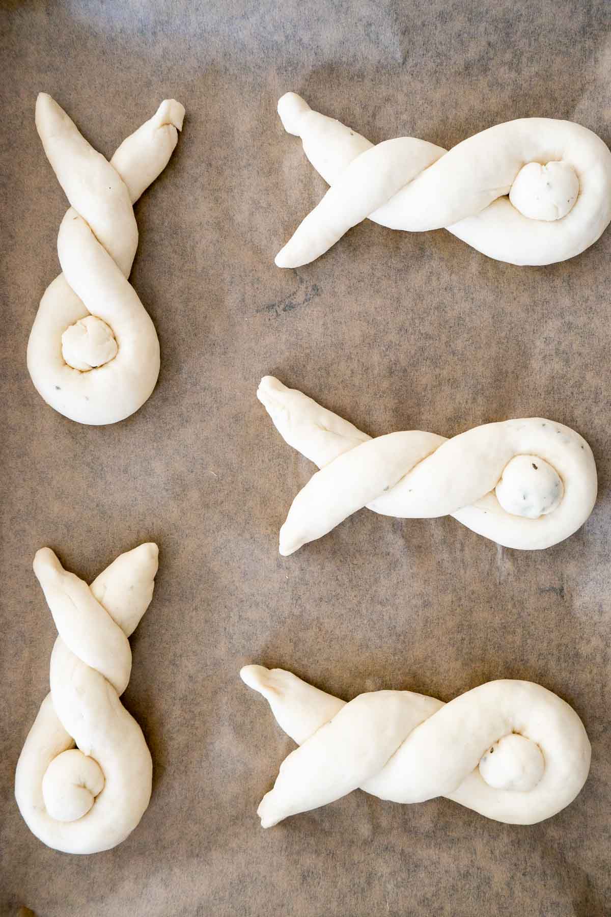Petits pains en forme de lapin sur du papier sulfurisé.