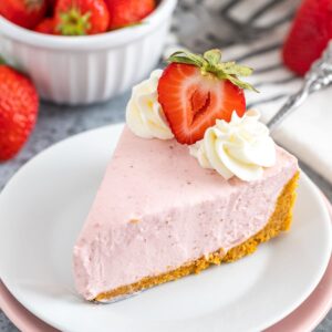 Une part de cheesecake aux fraises sur une assiette blanche