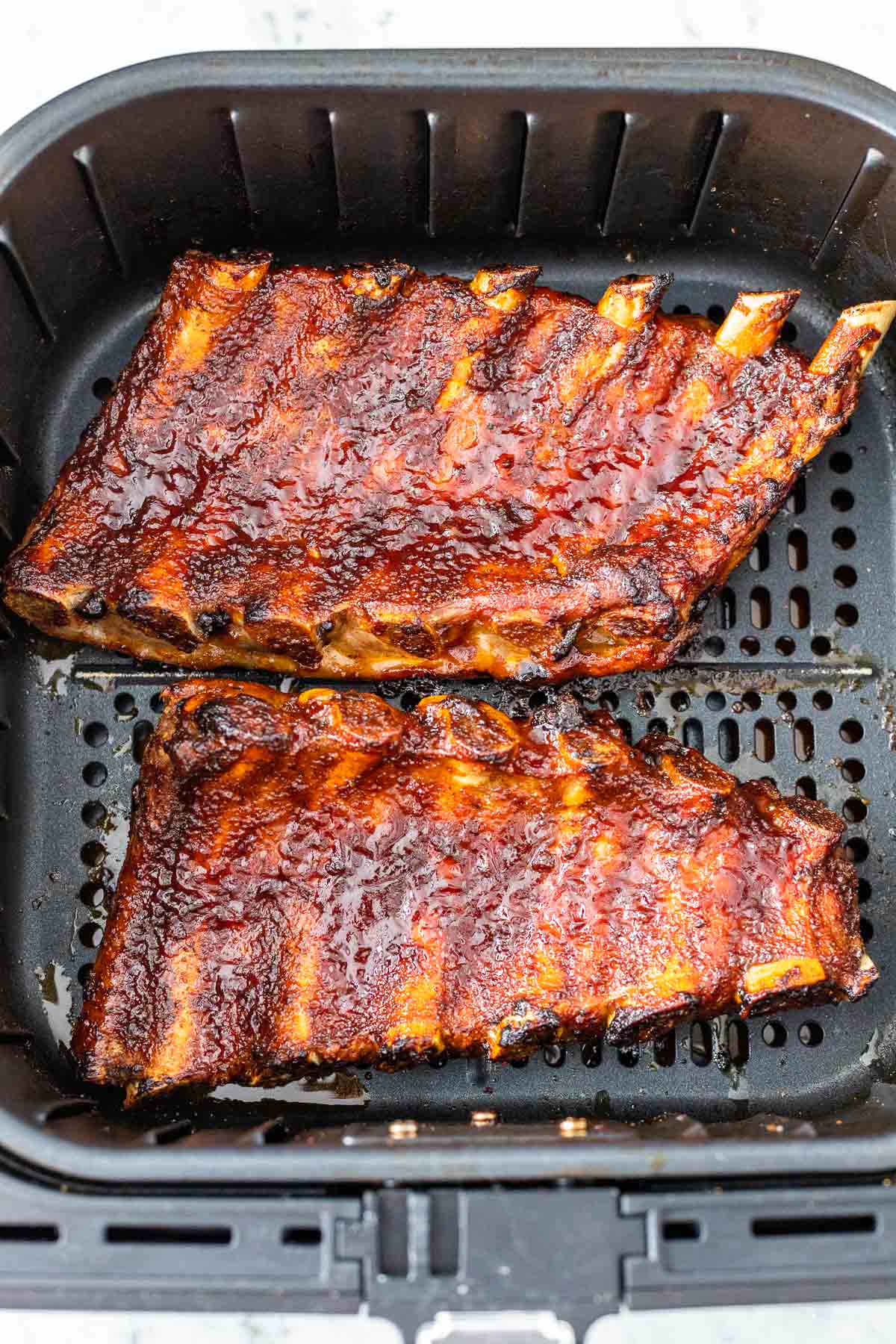 Une rack de côtes cuites dans un panier de friteuse à air