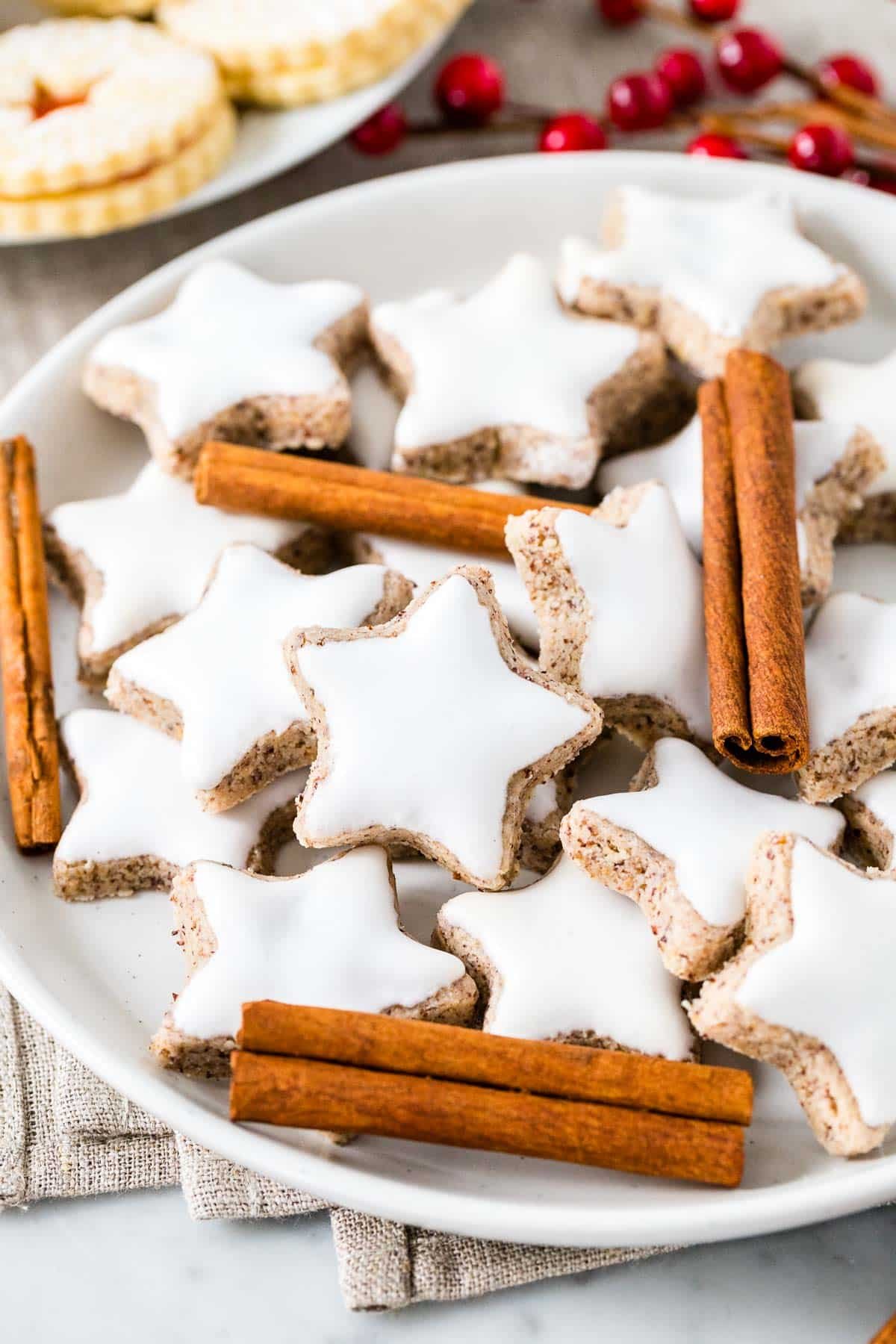 Une assiette d'étoiles à la cannelle, garnies de bâtons de cannelle.