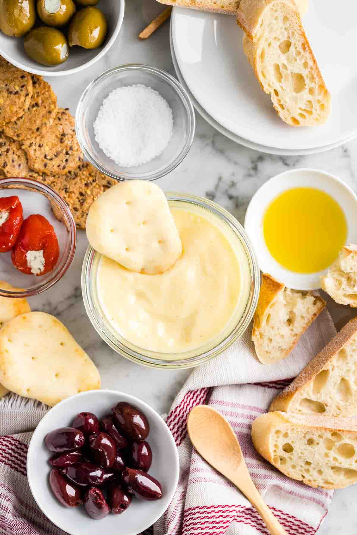 Amuse-gueules et pain à côté d'un bol d'aïoli.