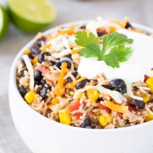 Haricots noirs et riz dans un bol, garnis de fromage et de crème aigre