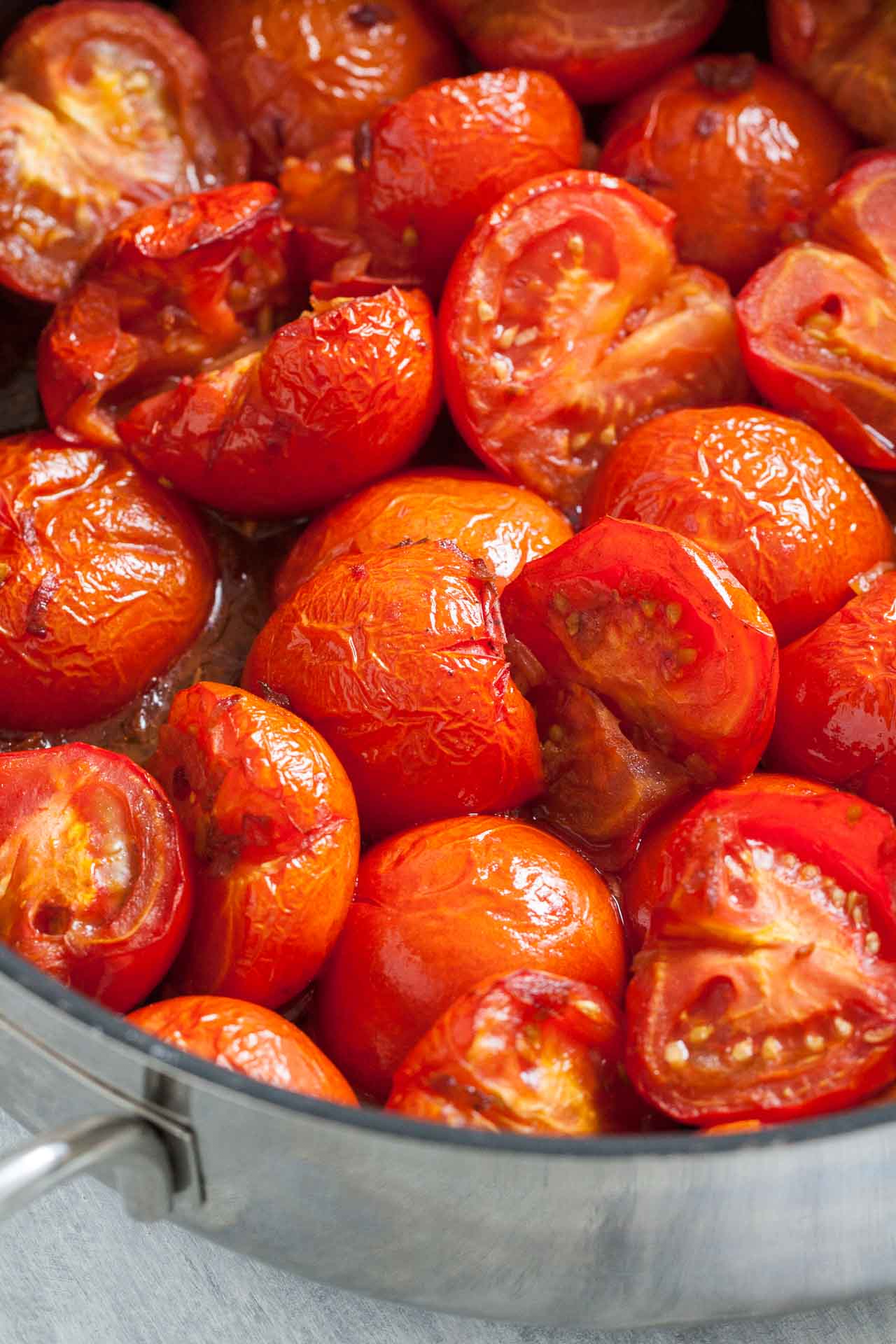 Tomates rôties avec une peau ridée dans une grande poêle.
