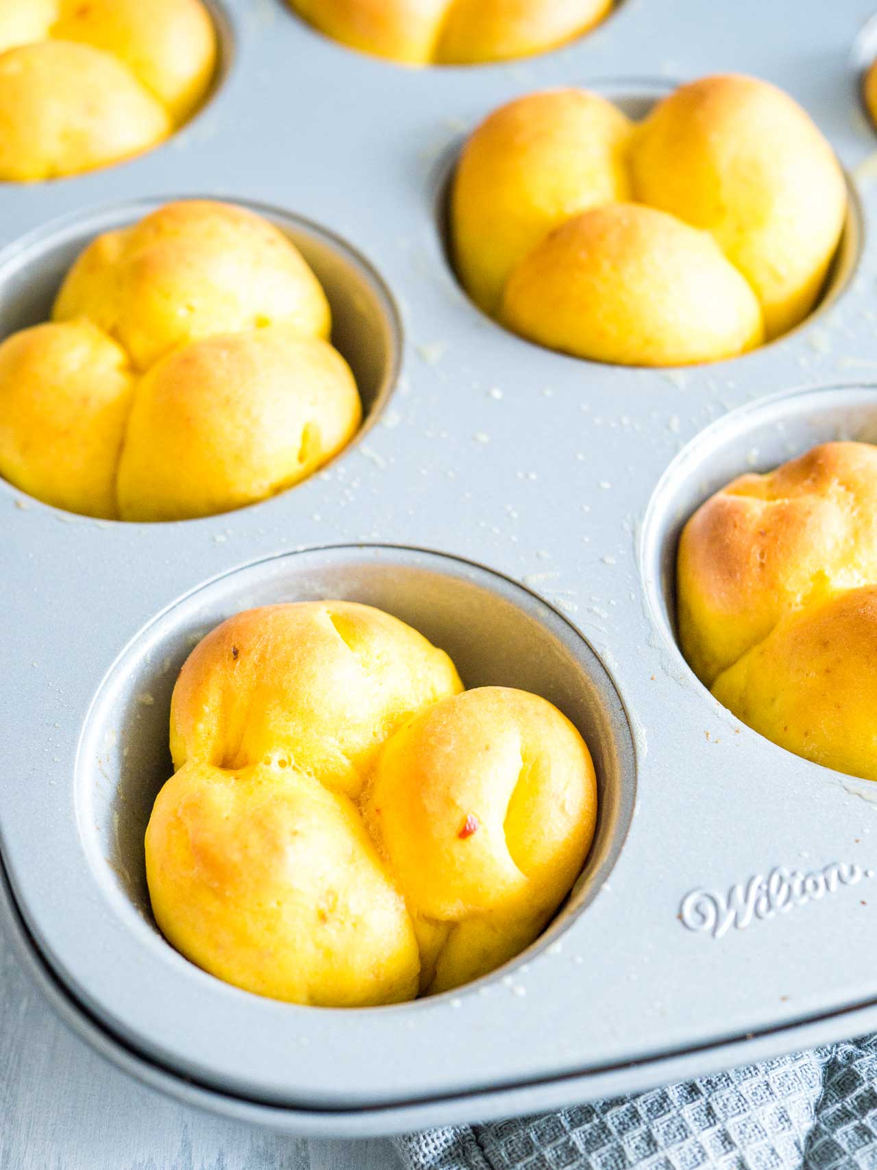 Un moule à muffins avec des petits pains à la citrouille cuits.