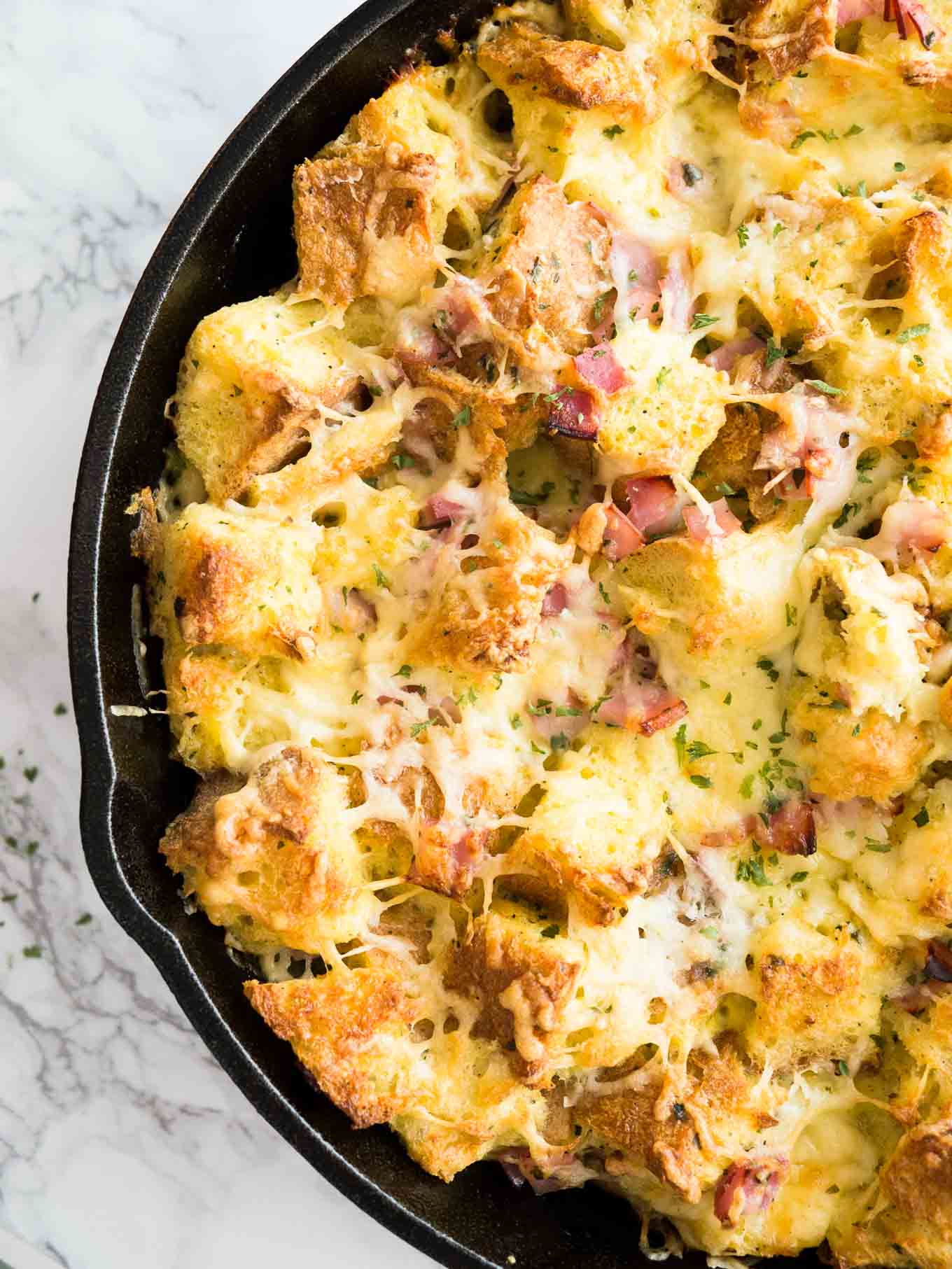 Ce gratin de jambon et de fromage pour le petit-déjeuner est le plat parfait pour utiliser des restes ! Un délicieux plat à cuire pour le petit déjeuner ou une strata à base de pain, de fromage et de jambon qui deviendra le favori de votre famille.