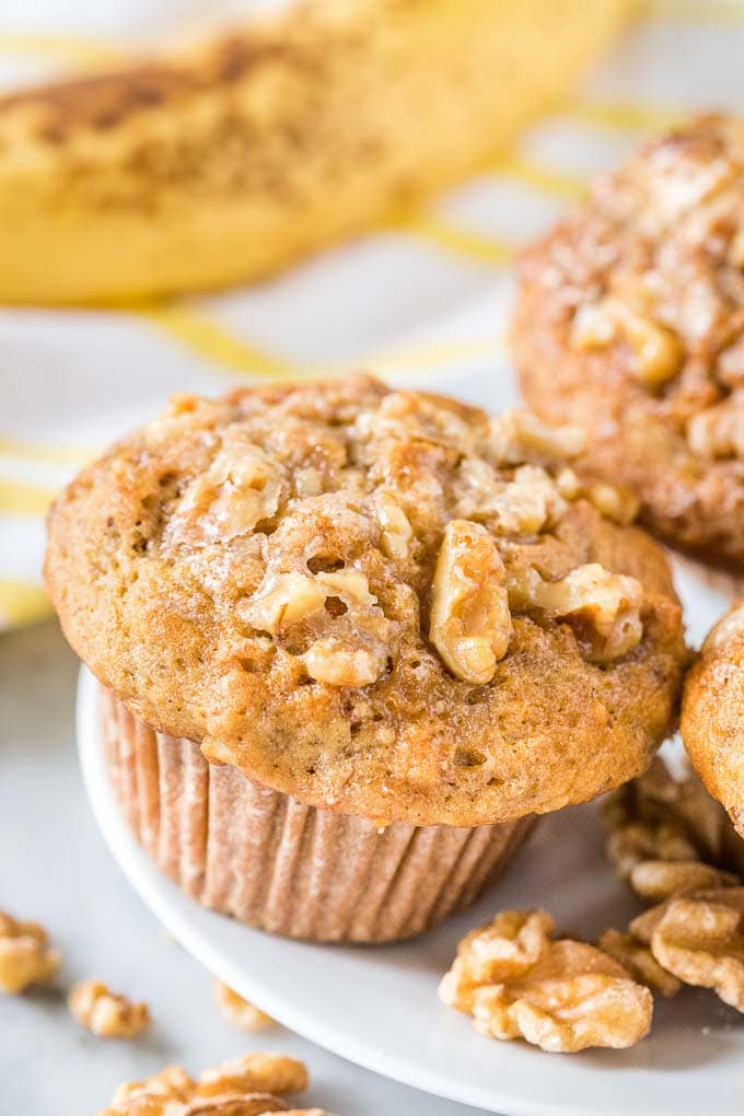 Muffins à la banane avec un glaçage aux noix sur une assiette.