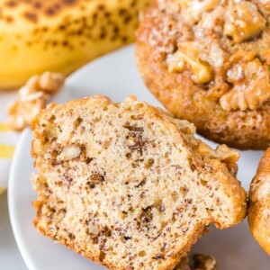 Muffins à la banane et aux noix sur une assiette avec une banane en arrière-plan