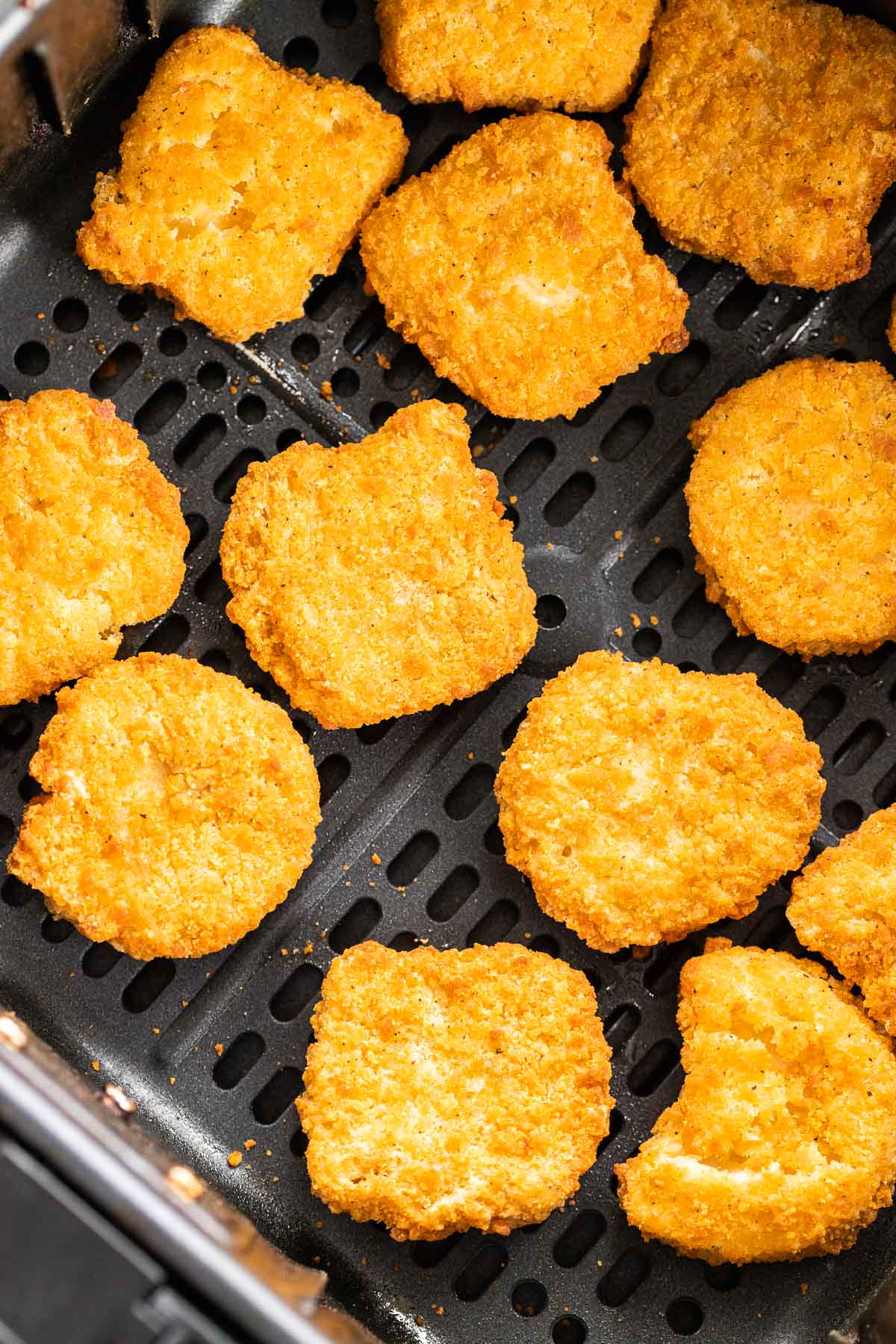 Nuggets de poulet frits à l'air dans un panier de friteuse à air.