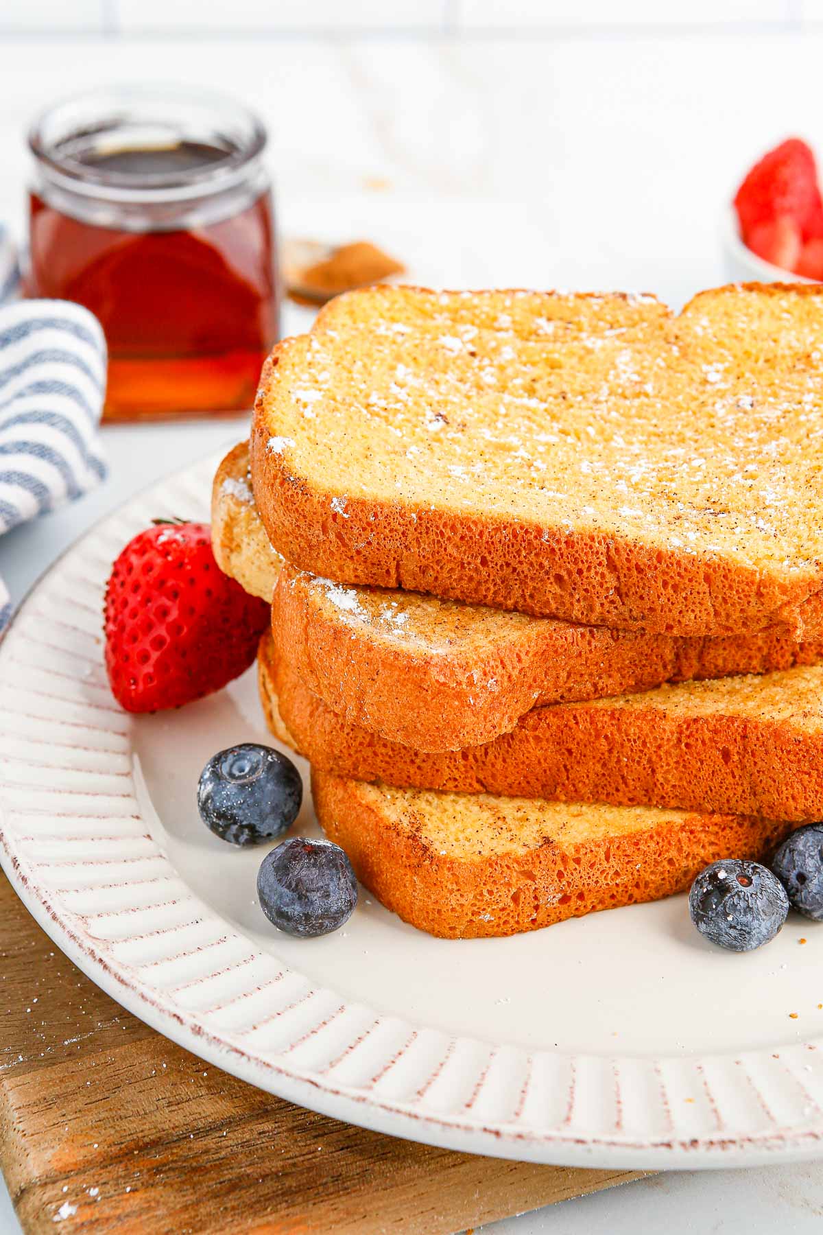 Une pile de pain perdu sur une assiette blanche.