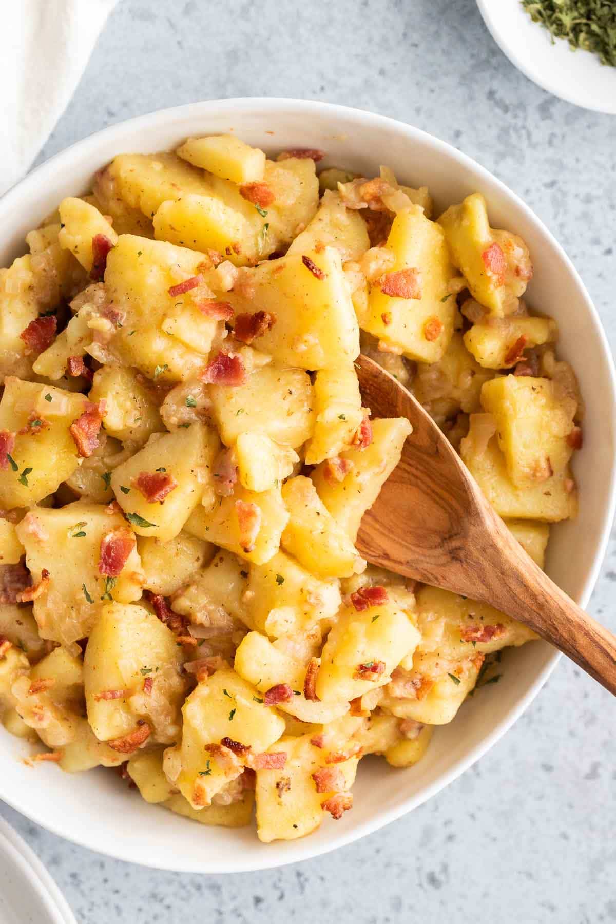 Salade de pommes de terre allemande dans un plat de service avec une cuillère dépassant
