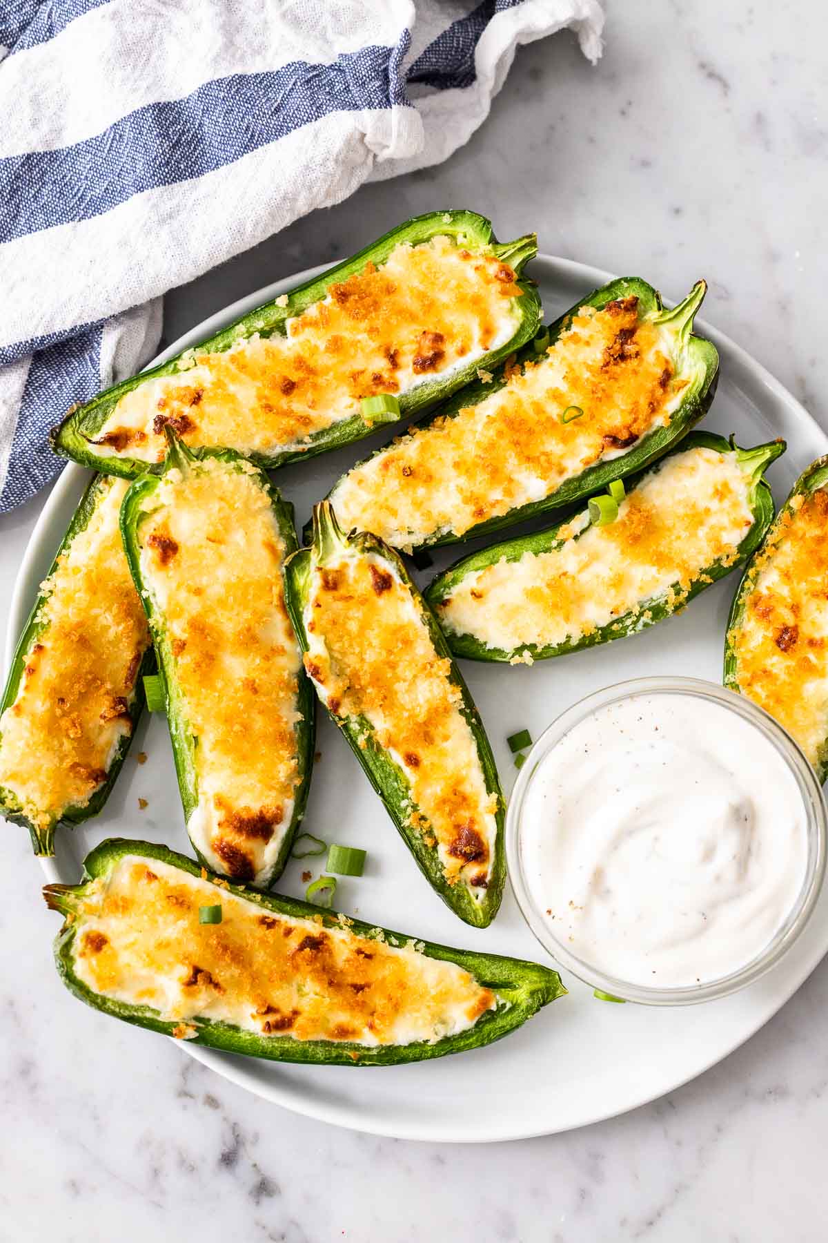 Jalapeno Poppers arrangés sur une assiette blanche avec un petit bol rempli d'une sauce à côté