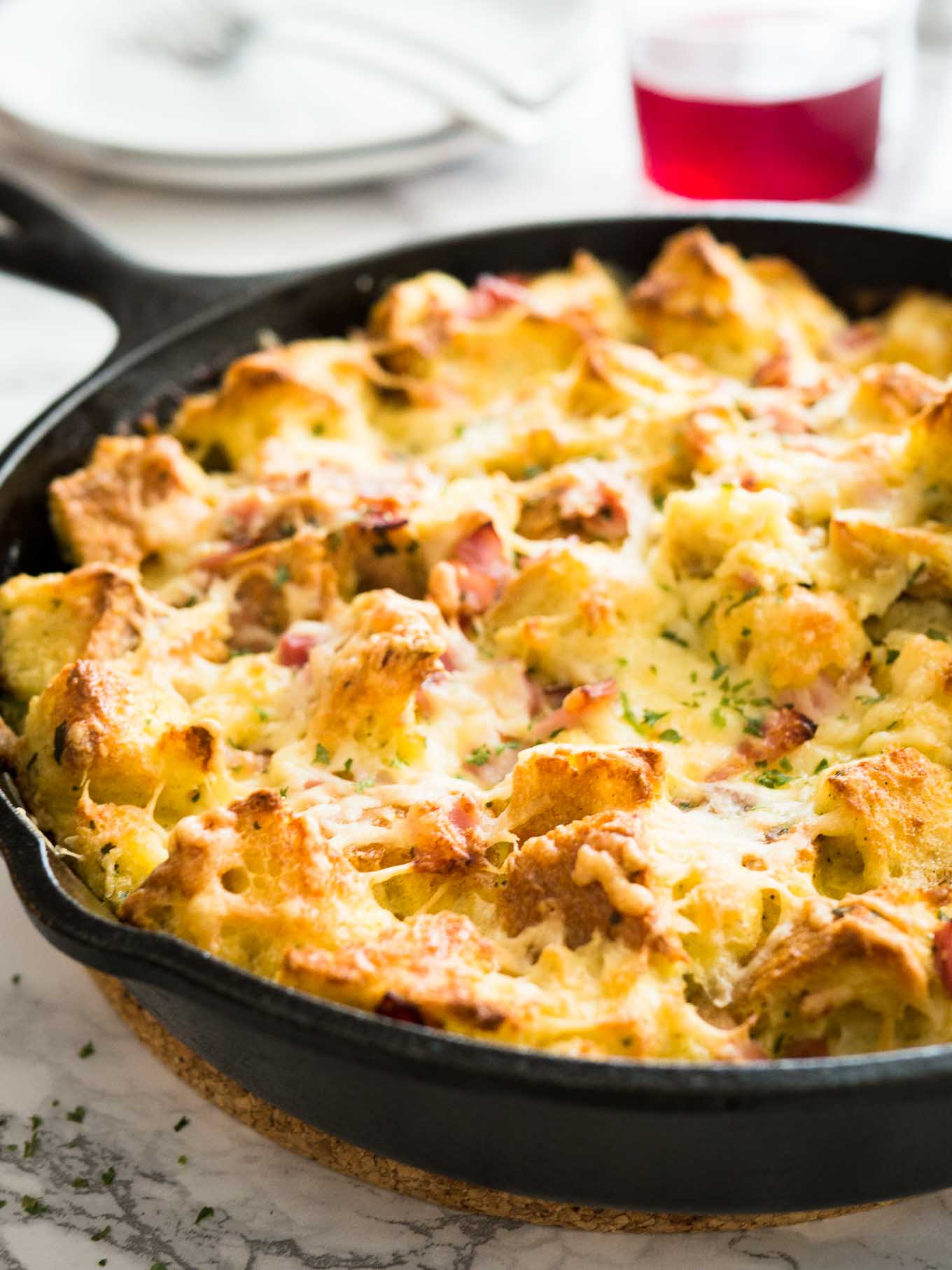 Ce gratin de jambon et de fromage pour le petit-déjeuner est le plat parfait pour utiliser des restes ! Un délicieux plat à cuire pour le petit déjeuner ou une strata à base de pain, de fromage et de jambon qui deviendra le favori de votre famille.