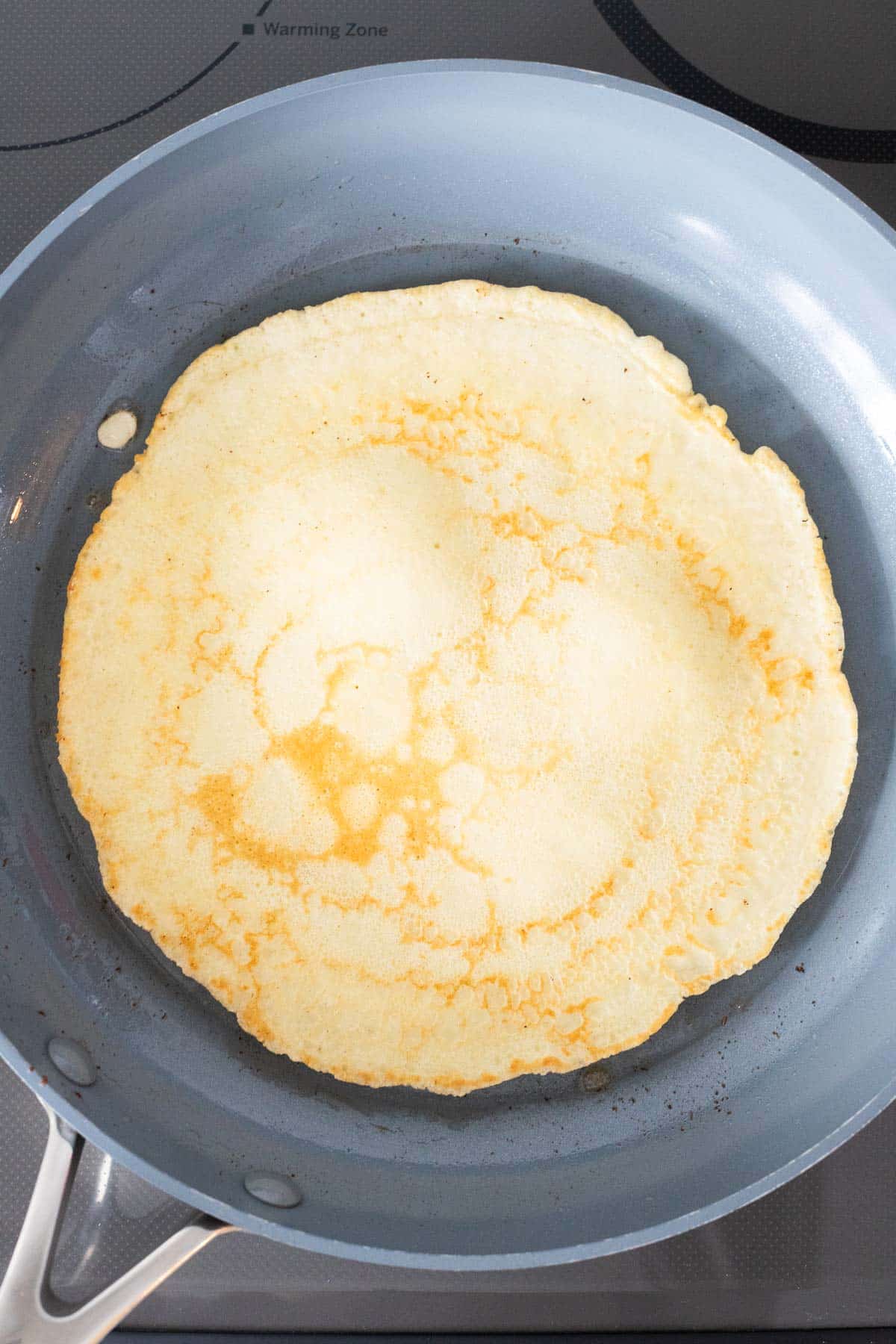 La crêpe dans une poêle après l’avoir retournée.
