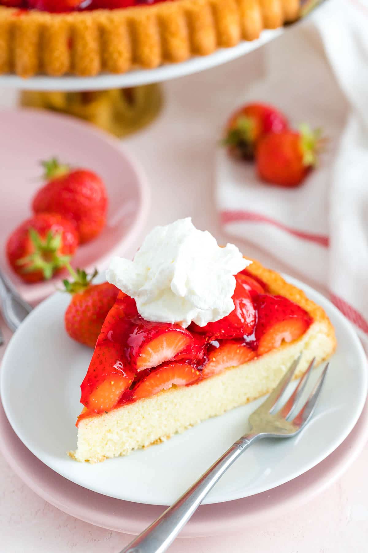 Une part de gâteau aux fraises sur une assiette avec une fourchette