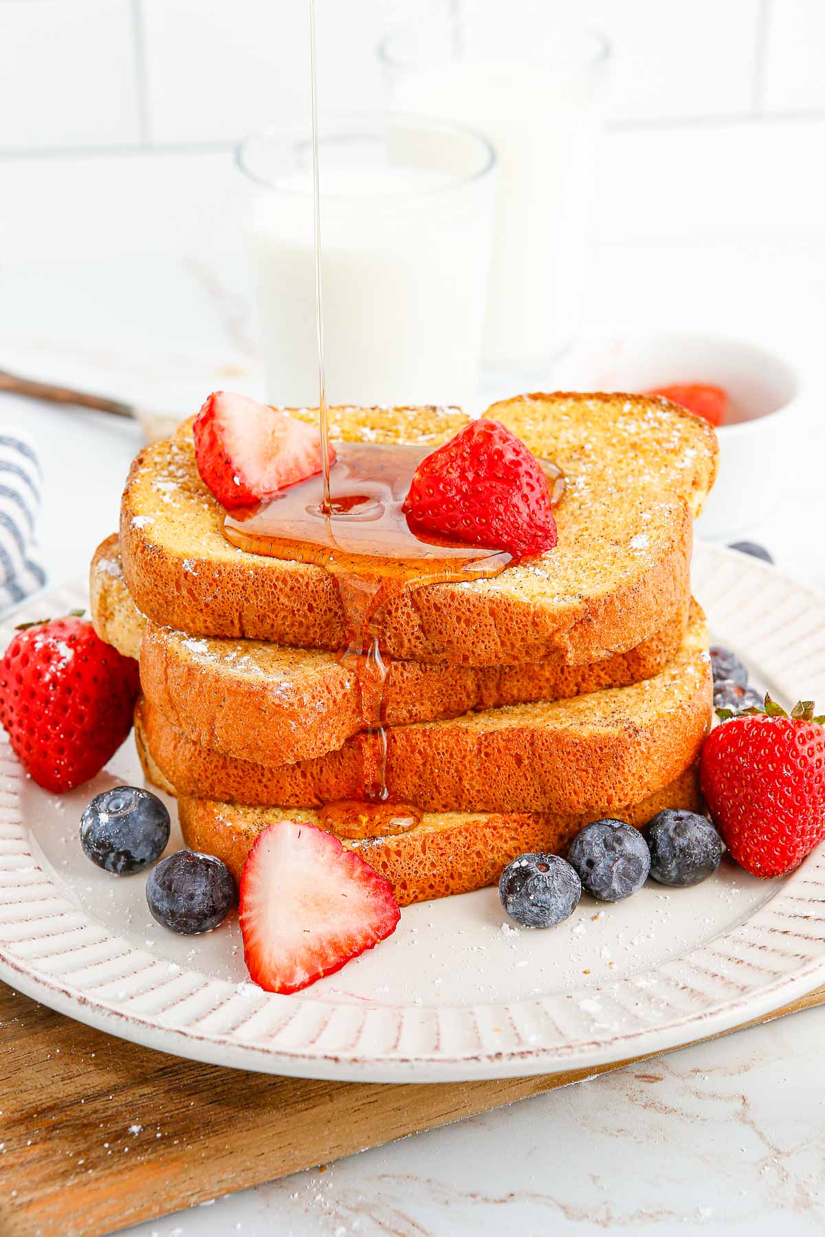 Sirop versé sur du pain perdu garni de fruits.