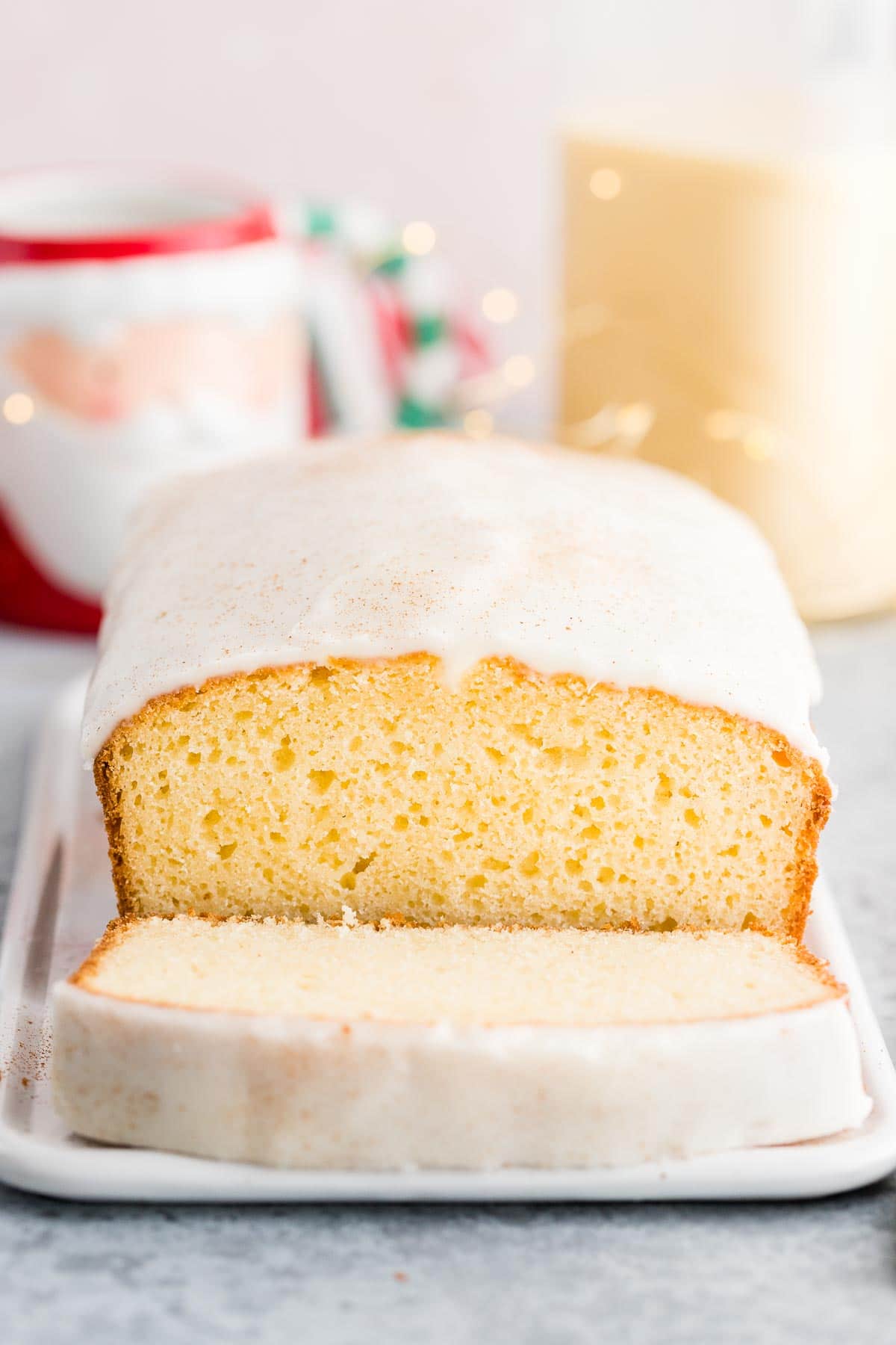 Un gâteau de Noël sur un plateau de service avec une tranche devant.