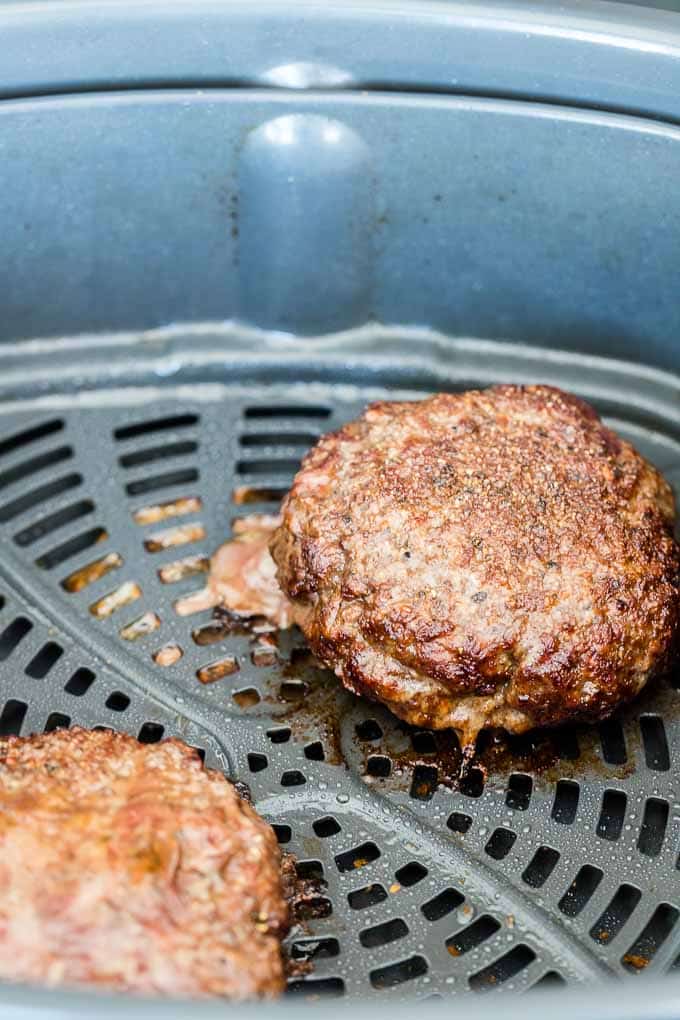 Deux galettes de hamburger cuites dans le panier de la friteuse à air