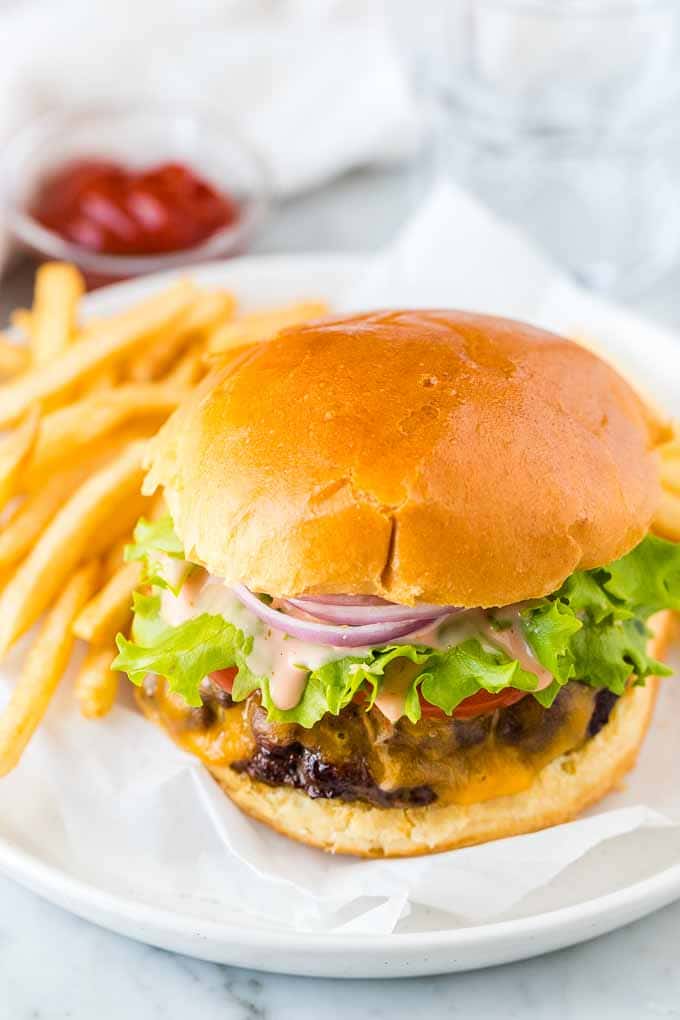 Un hamburger sur une assiette avec des frites sur le côté
