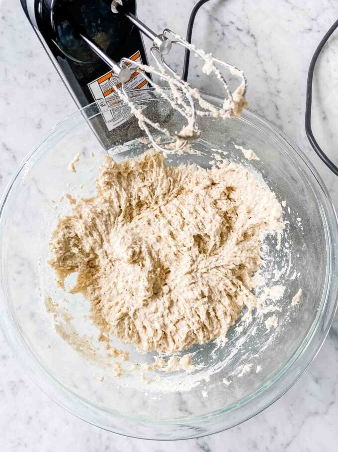Pâte à pain à la bière dans un bol avec un mixeur à main à côté