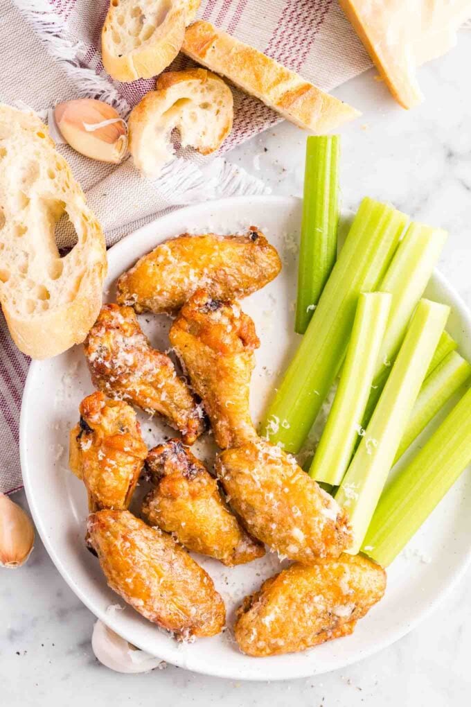 Ailes de poulet et bâtons de céleri sur une assiette avec des tranches de pain sur le côté