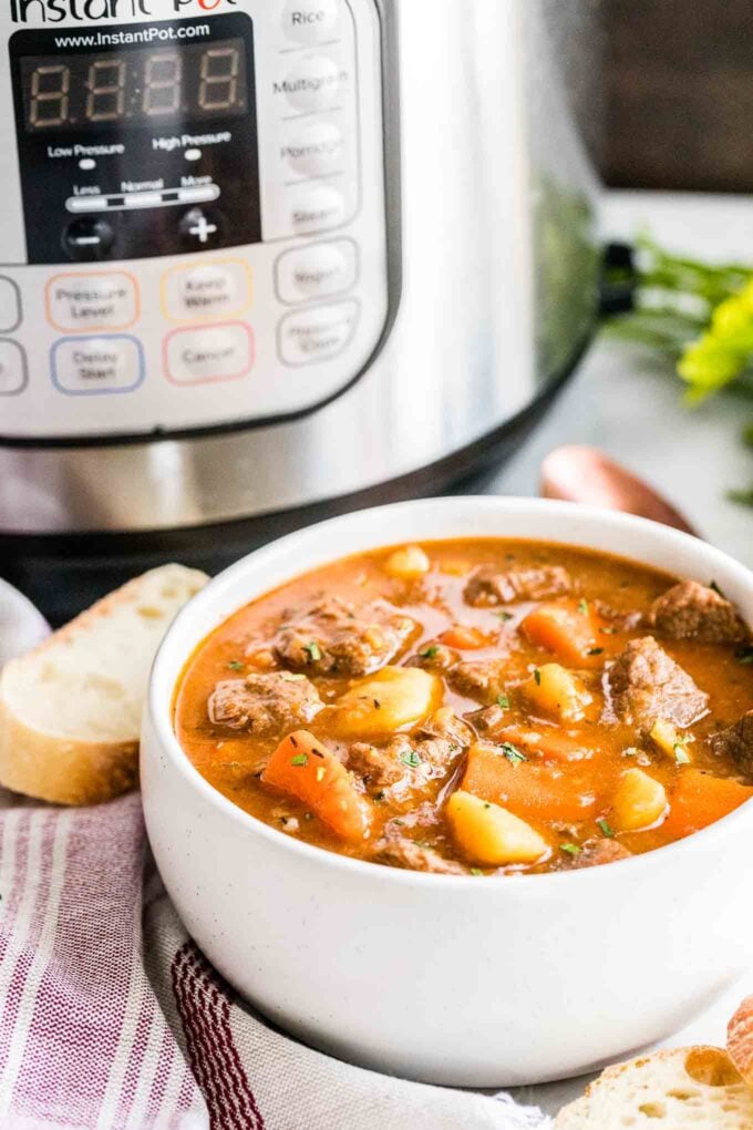 Un bol de ragoût de bœuf à côté d'une cocotte-minute