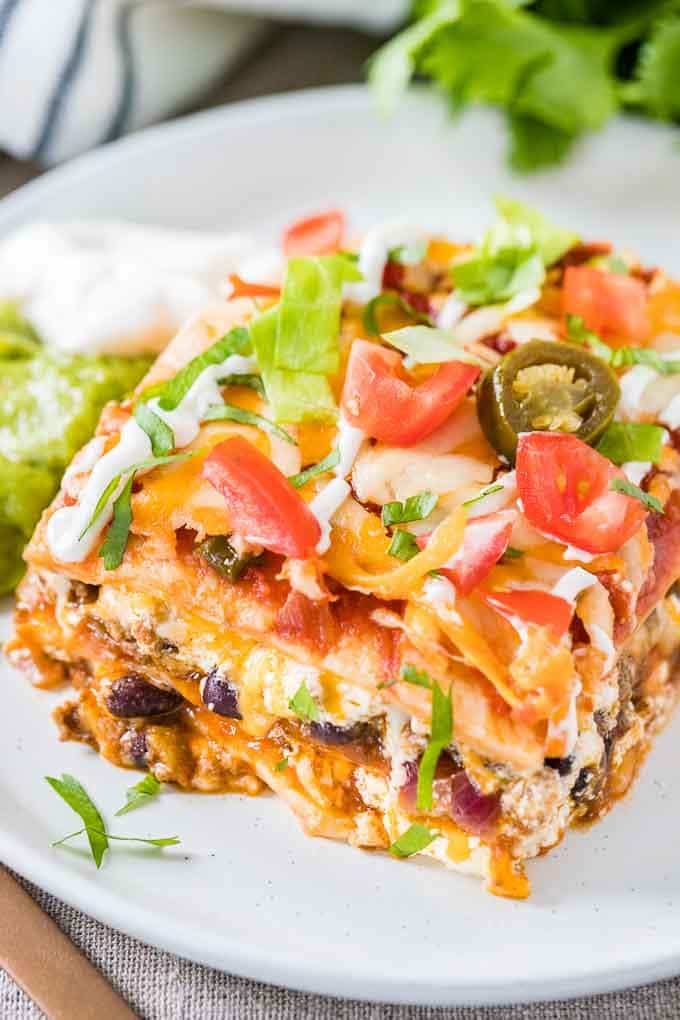 Un morceau de lasagne taco avec guacamole et crème aigre
