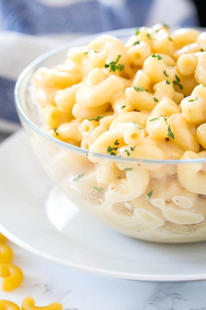Gros plan sur le Mac and Cheese dans un bol en verre sur une assiette blanche