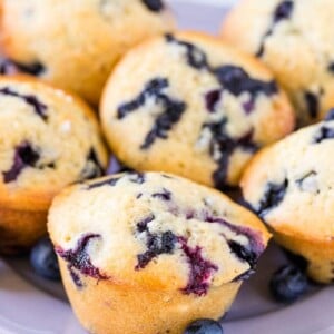 Muffins aux bleuets sur une assiette violette garnie de bleuets frais