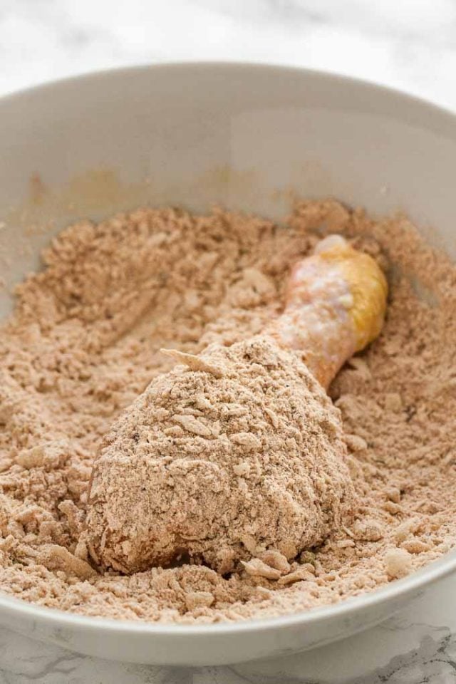 cuisse de poulet crue reposant dans le mélange de panure