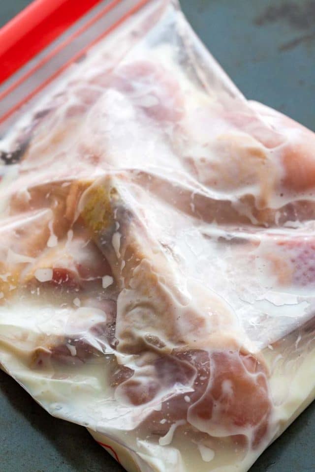 cuisse de poulet crue dans un sac en plastique rempli de babeurre