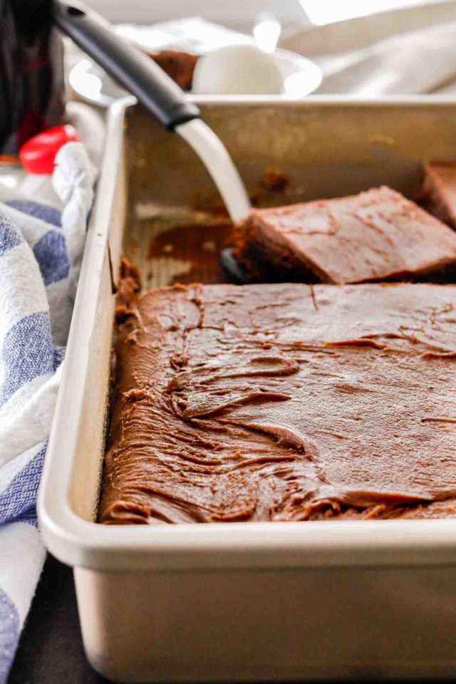 gâteau au coca cola dans un plat de cuisson avec une spatule prenant un morceau