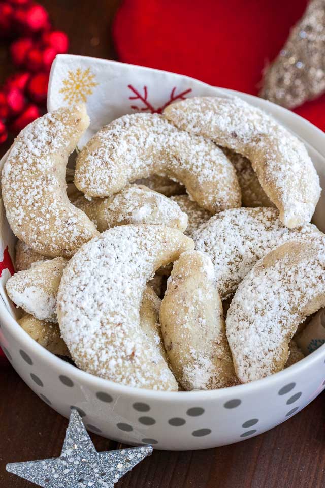 Gros plan sur un bol blanc avec une serviette, contenant des biscuits Vanillekipferl.