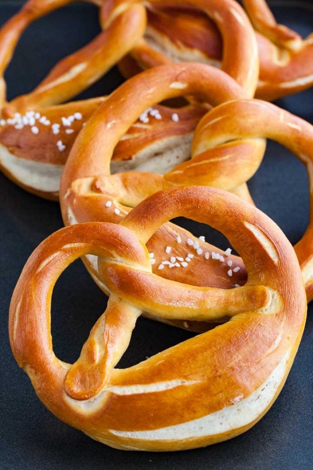 Trois bretzels sur une surface bleu foncé.