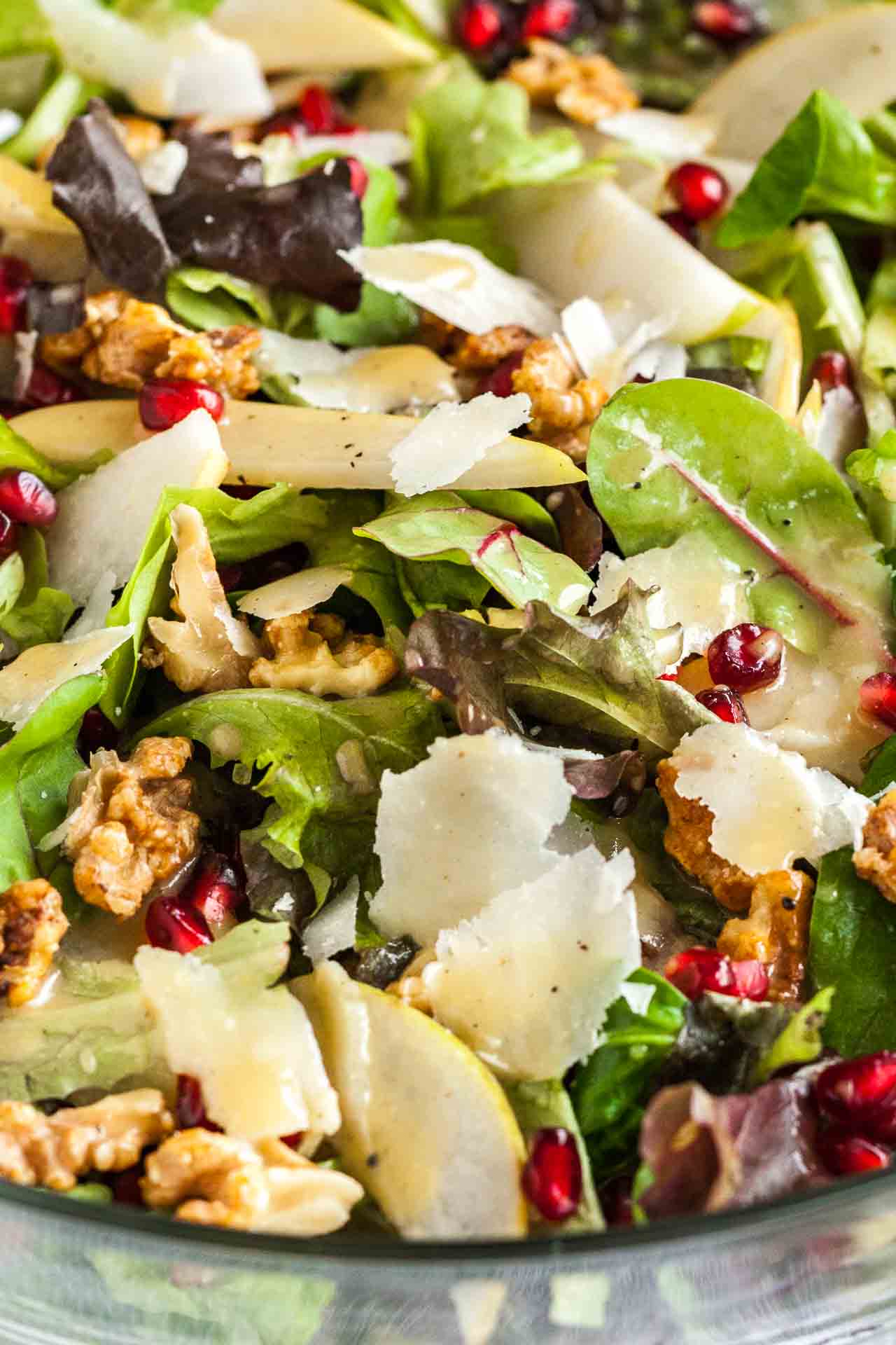 Gros plan de salade de poire et de grenade avec noix.