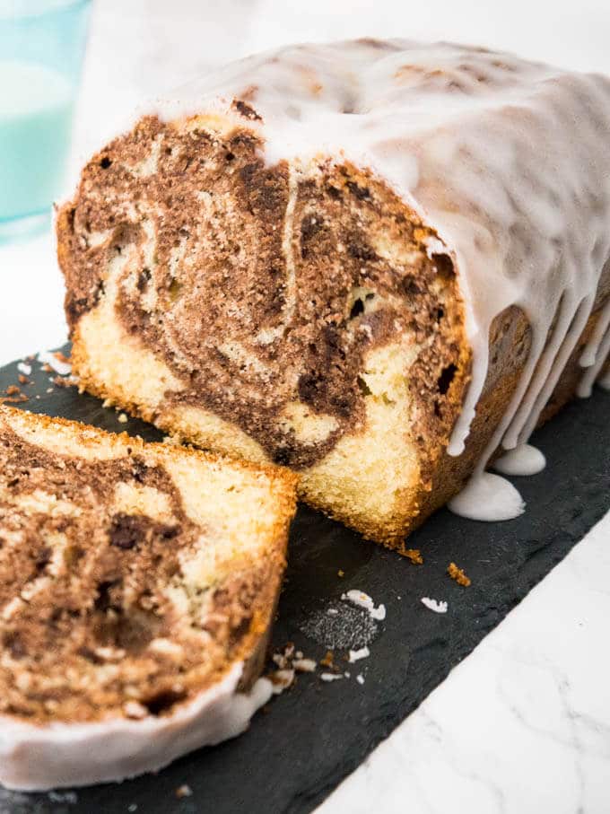 Le Gâteau Marbré à l'Orange est composé de deux pâtes parfumées à l'orange ! Ce délicieux gâteau a un glaçage au citron sur le dessus et se marie parfaitement avec une tasse de café.