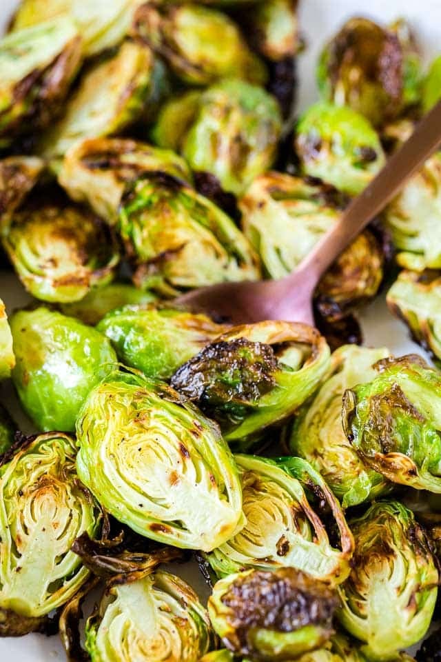 Gros plan sur des choux de Bruxelles rôtis à la friteuse à air avec une cuillère