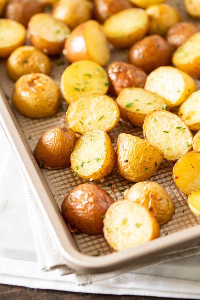 Une plaque de cuisson avec des pommes de terre rôties, garnies de persil.