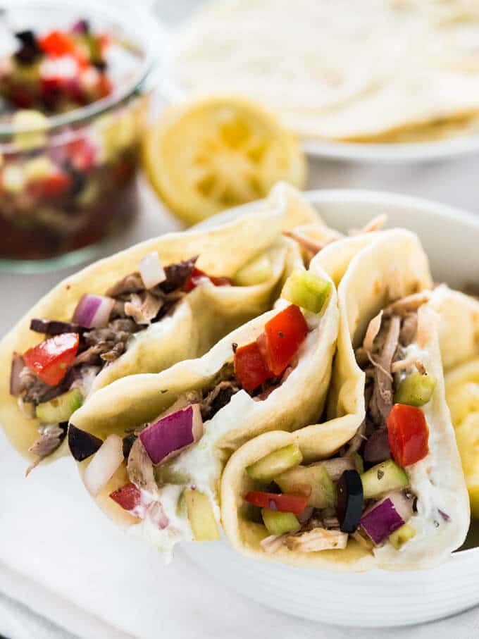 Délicieux tacos grecs avec tzatziki fait maison, gyros de porc effiloché à la mijoteuse et salsa grecque. Servis sur des tortillas de farine maison ! Une super variante des tacos classiques !